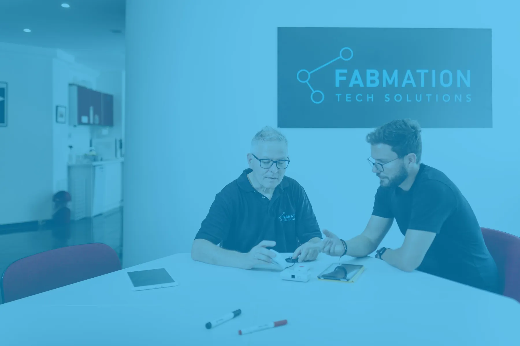Zwei FABMation-Mitarbeiter im Beratungsgespräch an einer Anlage